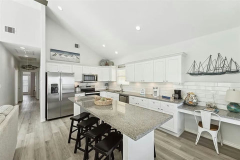 White kitchen with a granite island and bar stools