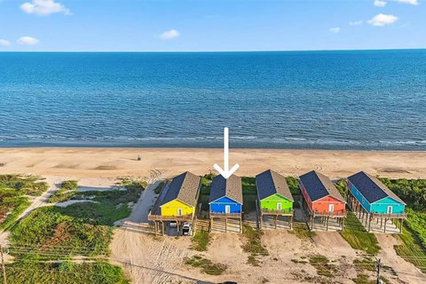 The blue house sits right on the beach
