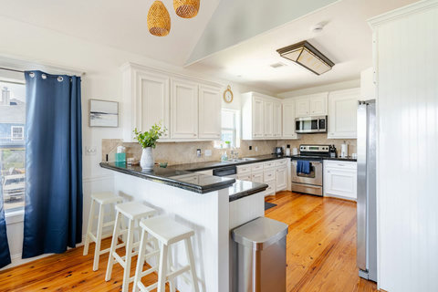 White kitchen with a breakfast bar and stainless appliances