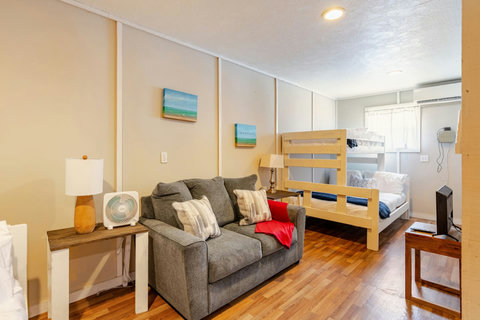 Bunk room with a bunk bed, loveseat and TV
