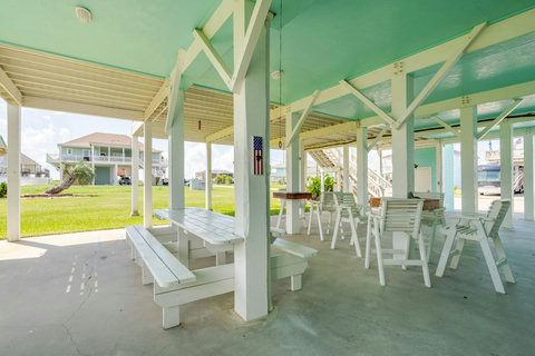 Long picnic tables in the shade under the house