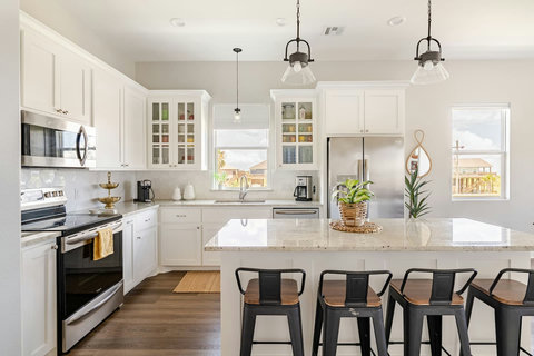White kitchen with a granite island and bar stools