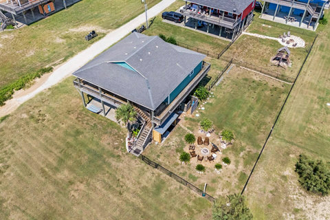 Fenced yard, fire pit and stairs to the deck from above