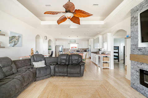 Open living room with an electric fireplace, flowing into the kitchen