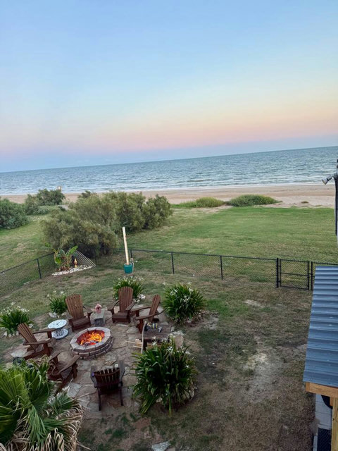 Fire pit and yard, with the beach just past the fence
