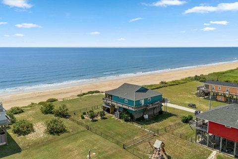 Aerial view: beachfront house with a fenced yard