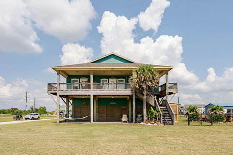 Covered decks on both levels and palm trees out front