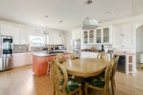 Chef's kitchen with a gas cooktop island, double oven and dining table