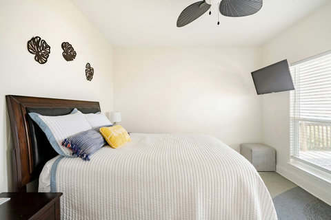 Queen bedroom with a wall-mounted TV