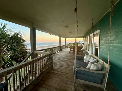Porch swing at sunset with the Gulf beyond