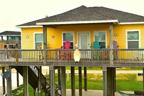 Sunny yellow beach house with a long front deck