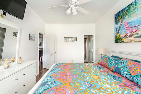 Queen bedroom with a dresser and TV