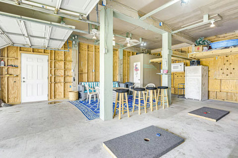 Garage hangout with bar stools and cornhole