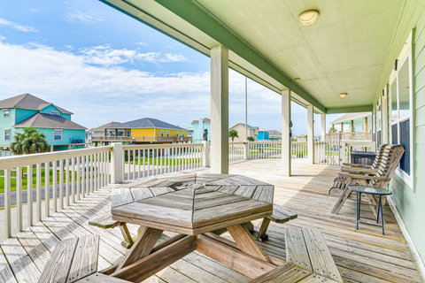 Covered deck with a picnic table and tall deck chairs