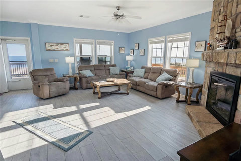 Living room with a stone fireplace and water views