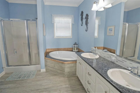Bath with a corner soaking tub, walk-in shower and double sinks