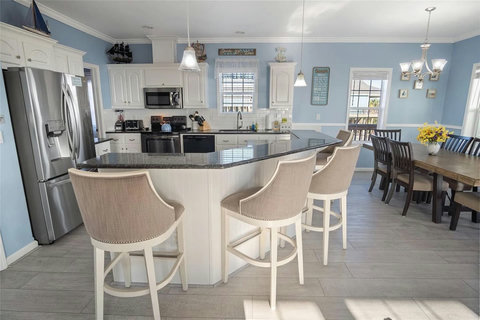 Big kitchen island with bar seating and a dining table for the crew