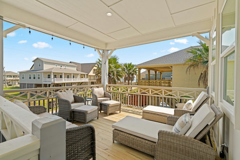 Covered upstairs deck with lounge chairs and a gas fire pit