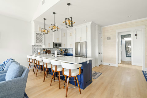 Kitchen with a navy island and bar stools
