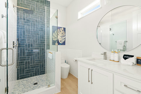 Glass walk-in shower with blue herringbone tile