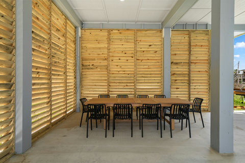 Long dining table in the shade under the house