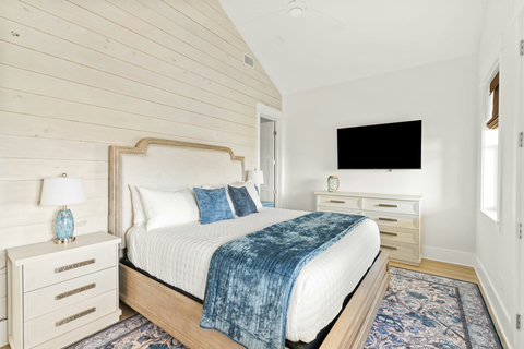 King bedroom with an upholstered headboard and smart TV