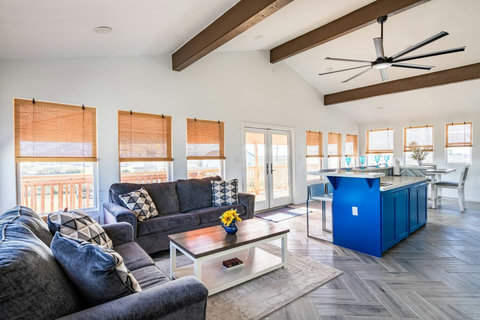 Upstairs living room with vaulted beams and a wall of windows