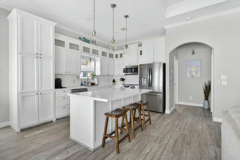 Kitchen with an island, tall cabinets and a stainless fridge