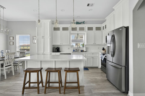 White kitchen with quartz counters and stainless appliances