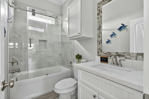 Hall bath with a tub and glass shower doors