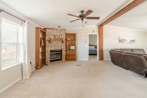 Living room with a brick fireplace and built-ins