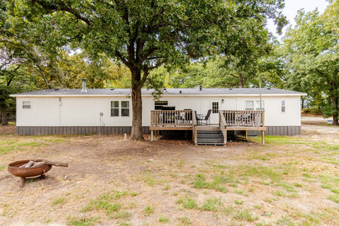Big yard with a fire pit and deck