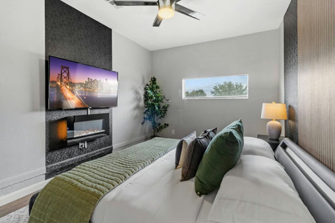 Bedroom with a fireplace and TV