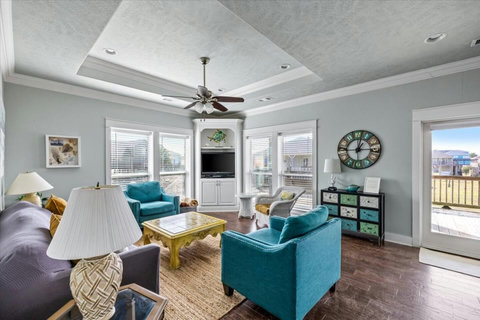Living room with teal armchairs and a corner TV