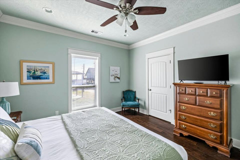 Bedroom with a TV, dresser and reading chair