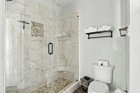 Glass walk-in shower with stone tile