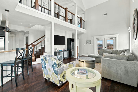 Two-story living room with a big sectional and loft above
