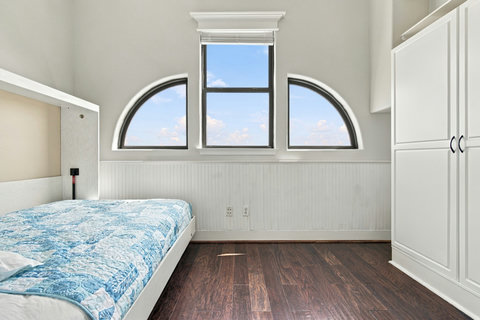 Bedroom with a Murphy bed and arched windows