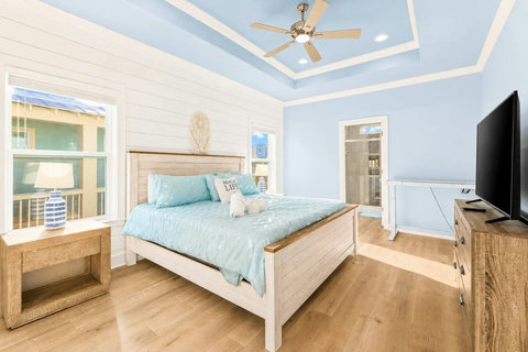King bedroom with a smart TV and shiplap accent wall