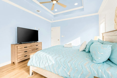 King bedroom with a dresser and TV