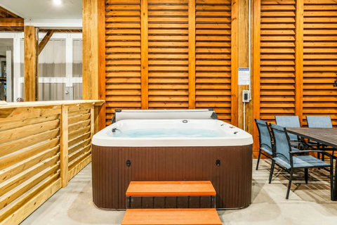 Hot tub with steps and dining table beside it