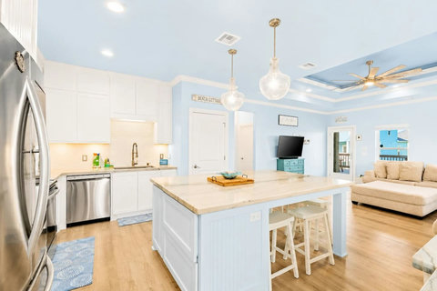 White kitchen with an island and stainless appliances