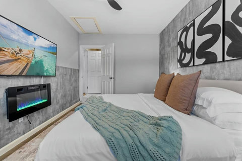 Bedroom with an electric fireplace and textured accent wall