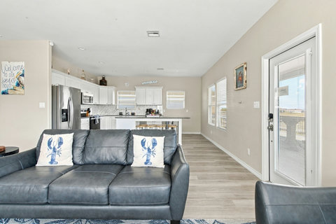 Sofa by the deck door, with the kitchen nearby