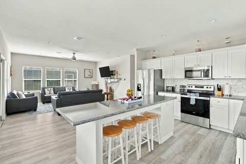 White kitchen with a granite island and bar stools