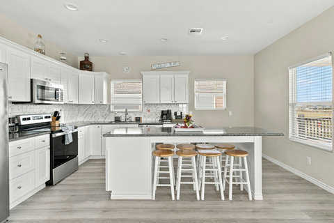 Kitchen with a big island, stainless appliances and bar stools