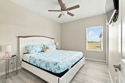 King bedroom with a wall TV and coastal bedding