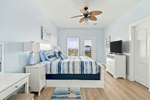 Primary suite with a TV, dresser and vanity desk