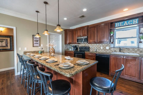 Kitchen with a long granite bar and seating for six