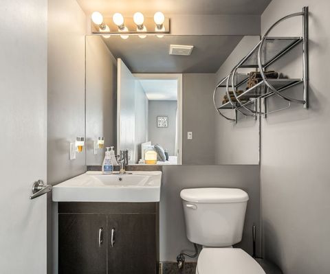 The bathroom, accentuated by a large mirror, offers a spacious and well-lit space for your personal routines, enhancing the overall comfort and utility of your stay.
